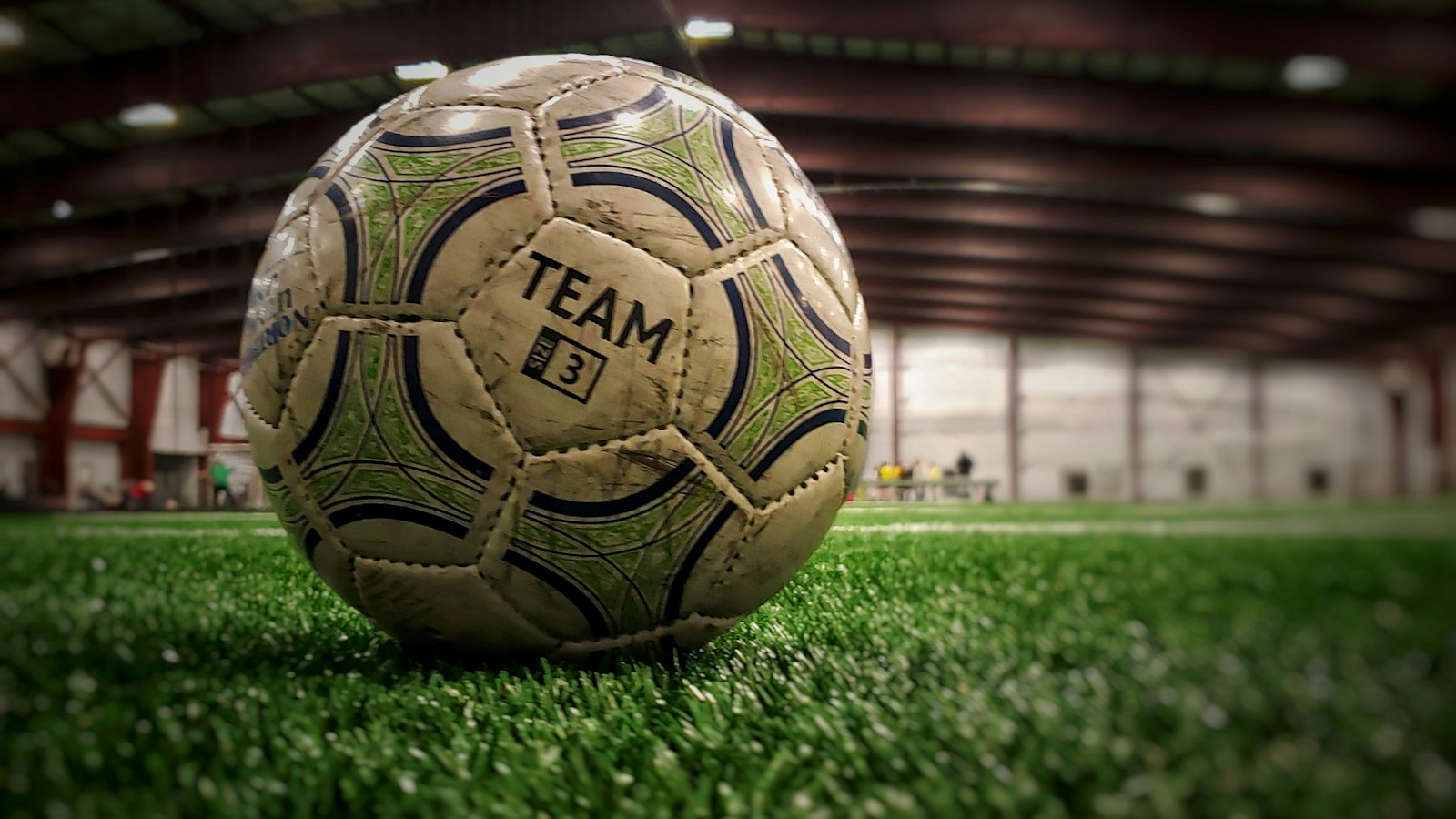 Balón de futbol usado sobre césped sintético; fotografía de archivo ilustrativa