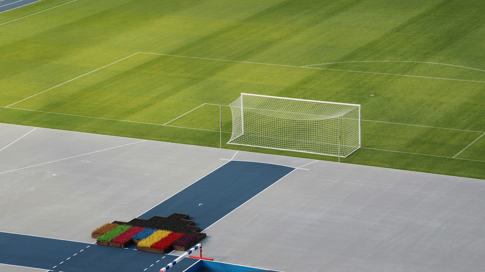 Cancha de futbol vacía con portería y pista; fotografía de archivo ilustrativa