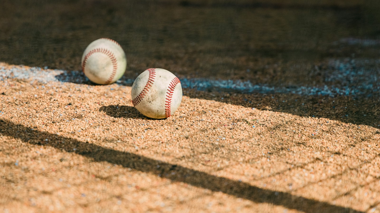 Dos pelotas de béisbol sobre la tierra del campo; fotografía de archivo ilustrativa