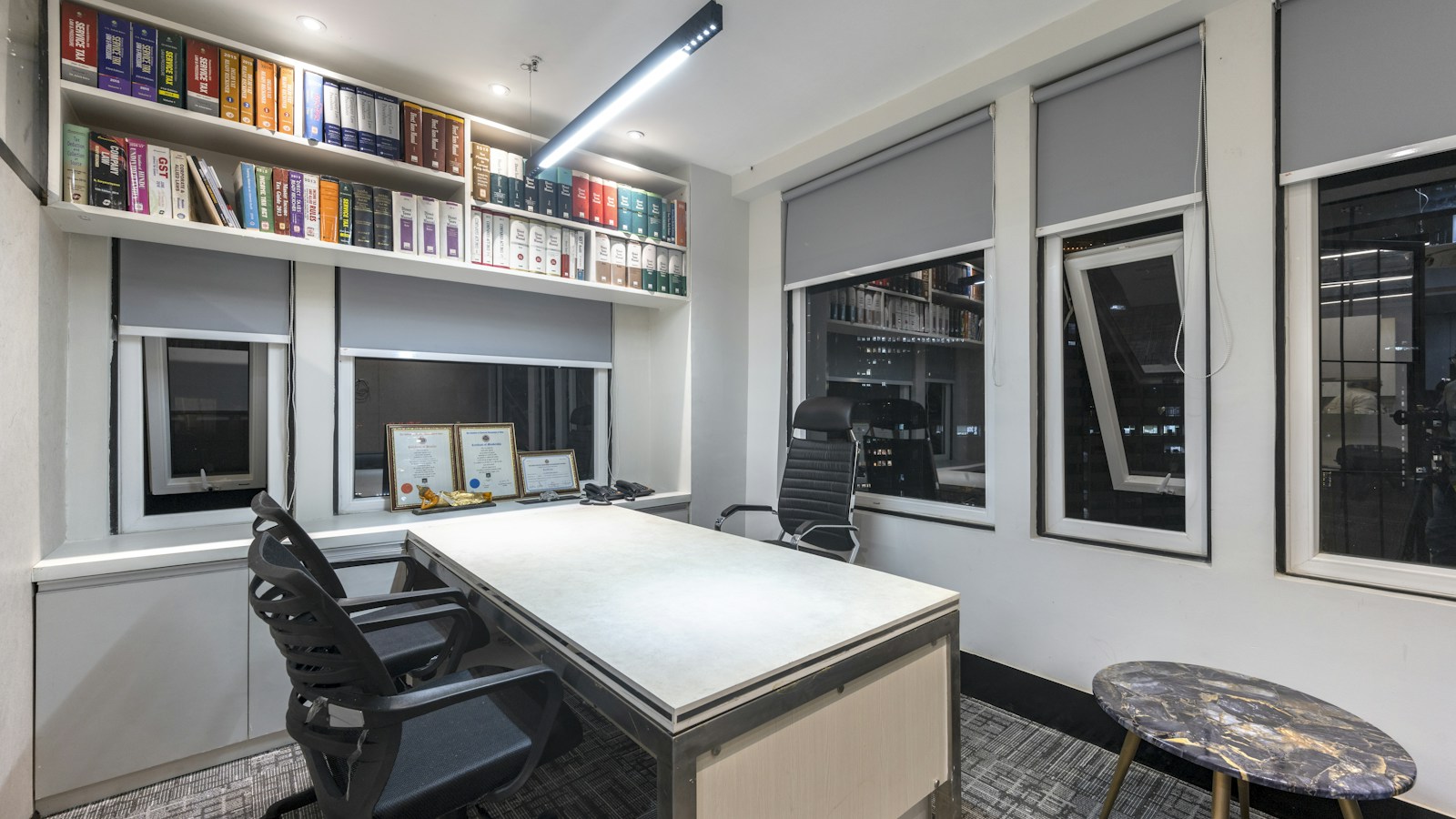 Sala de trabajo institucional vacía con escritorio y estanterías; fotografía de archivo ilustrativa
